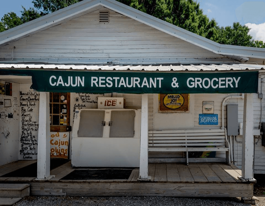 Exterior view of a Cajun restaurant and grocery with a green awning.