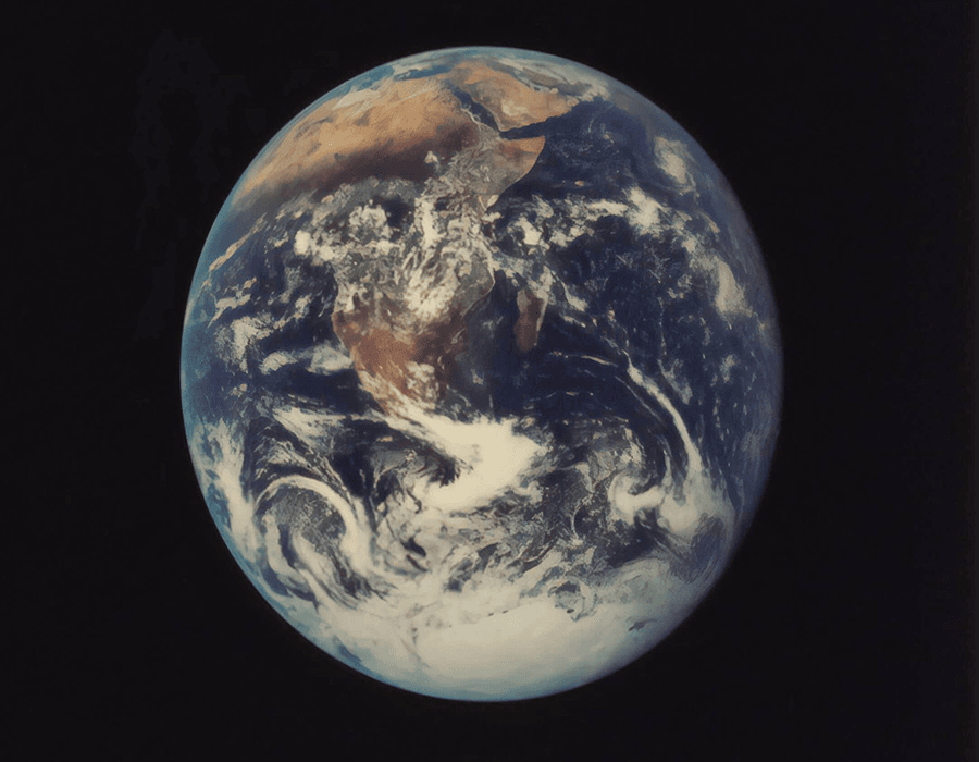 The Earth viewed from space, showcasing its blue oceans and brown continents.