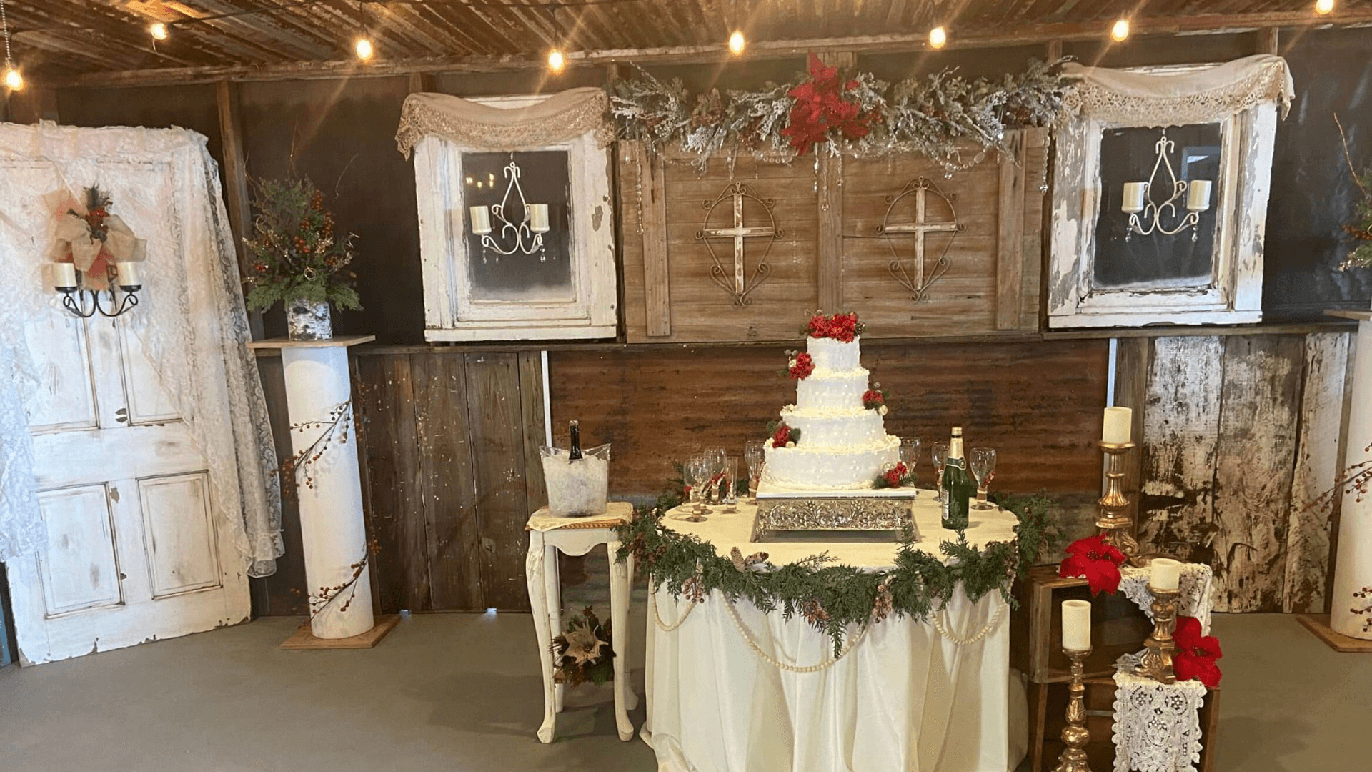 A beautifully decorated event space featuring a wedding cake surrounded by festive decor and soft lighting.