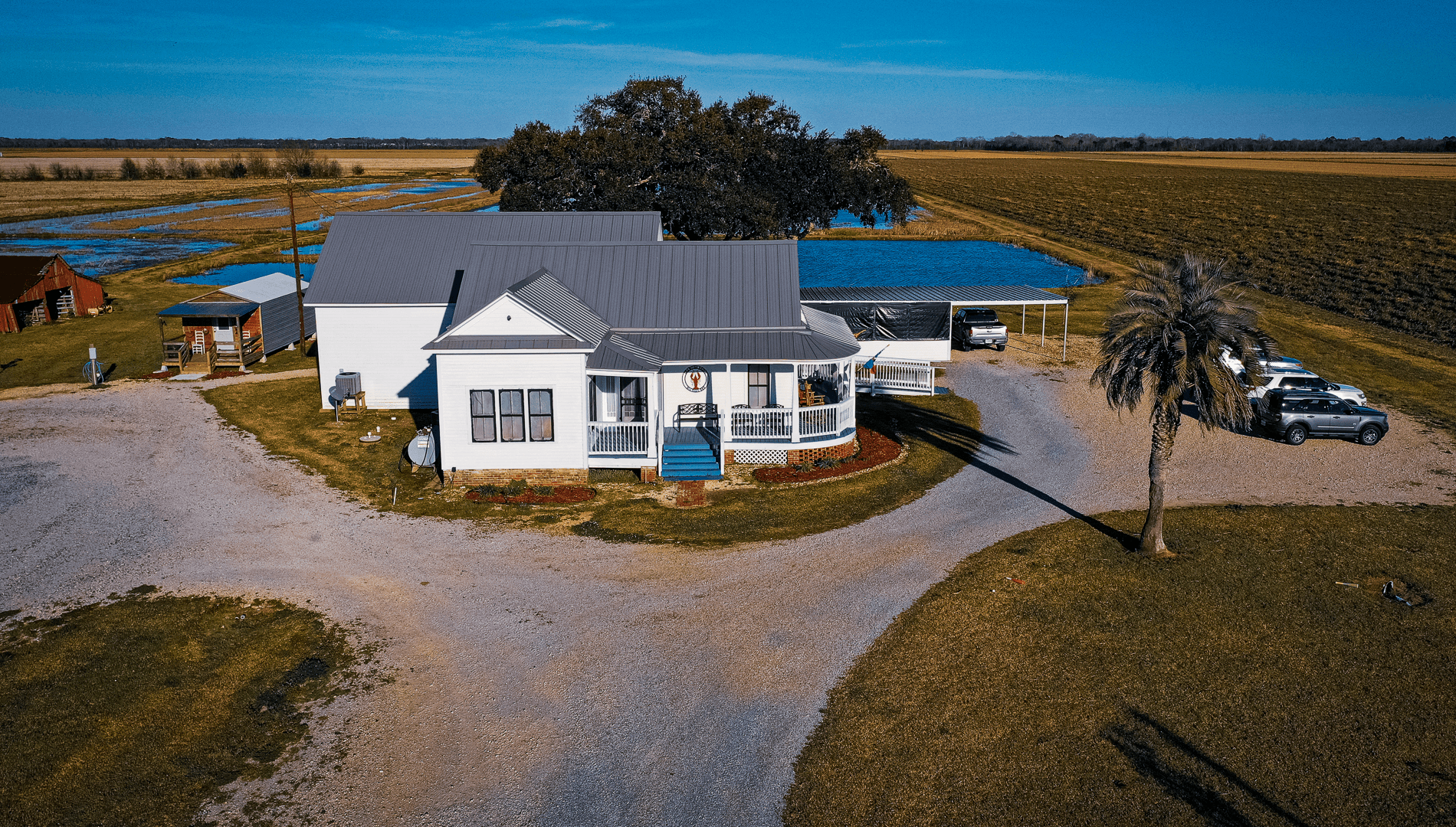 Aerial photo of Craw Fish Haven. To the left a Red barn and cabin, on center is the Haven's main building , and to the right parking. Craw Fish haven is surrounded by an open vast landscape that is breathtaking.